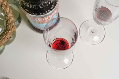 Cassis ins Glas füllen