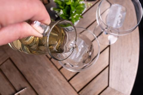 Waldmeisterwein wird auf Eiswürfel in ein Glas gegossen